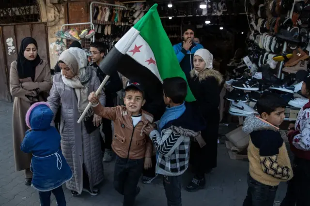 Trẻ em cầm lá cờ mới của Syria, ảnh chụp ngày 15/12/2024