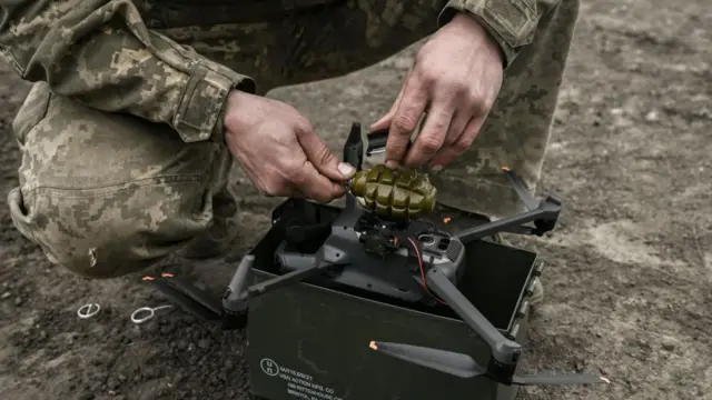ড্রোনের ওপর গ্রেনেড বাসনো হচ্ছে।