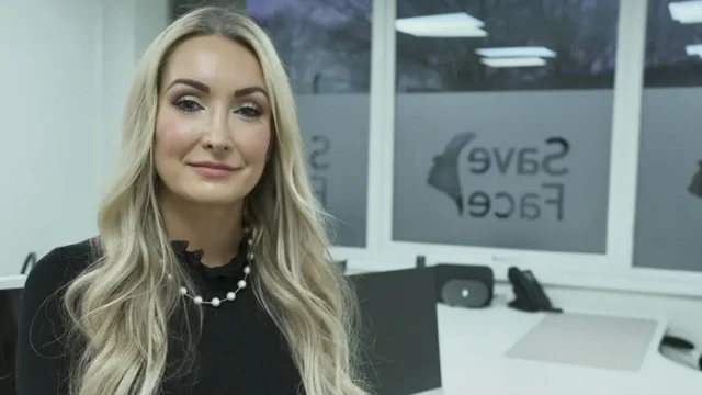 Ashton Collins, fundadora da Save Face, em seu escritório. Ao fundo, aparece o logo da organização na janela