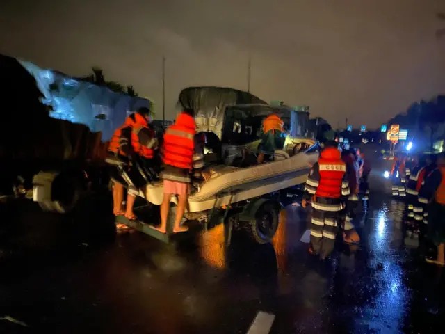 Lực lượng chức năng đưa ca nô xuống vùng ngập trên đường Cách Mạng Tháng 8  