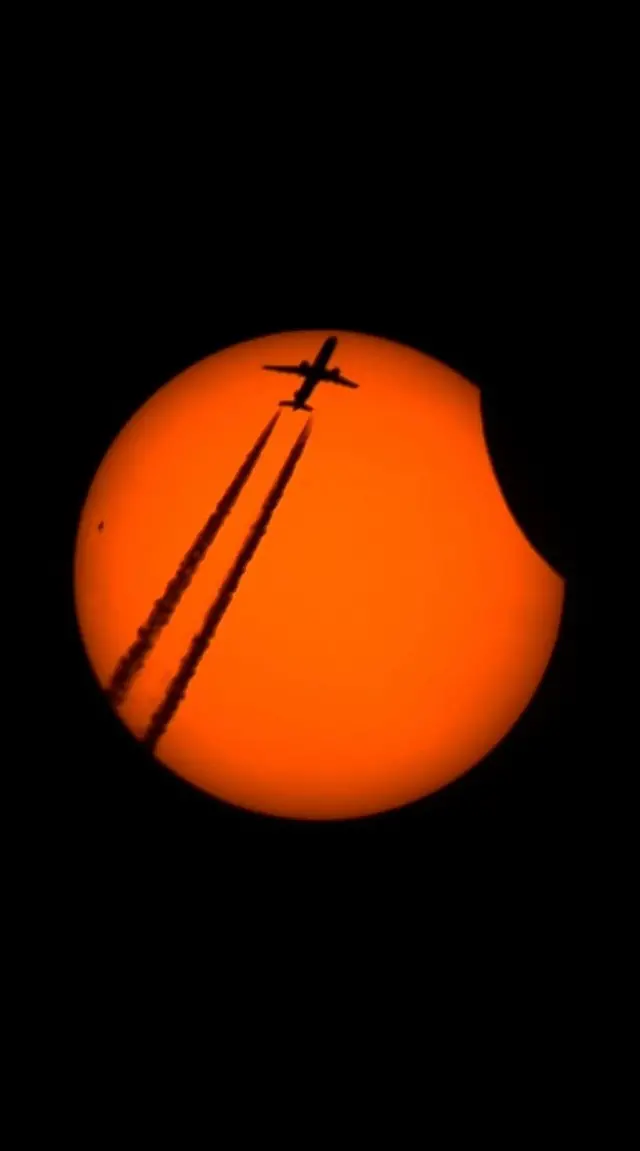 Ukwezi guca iruhande rw'Izuba, mu gihe indege iboneka imbere