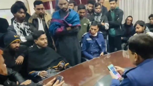 কালো চাদর পরিহিত মাহদী হাসান শায়েস্তাগঞ্জ থানার ওসির সামনে বসে কথা বলছেন।