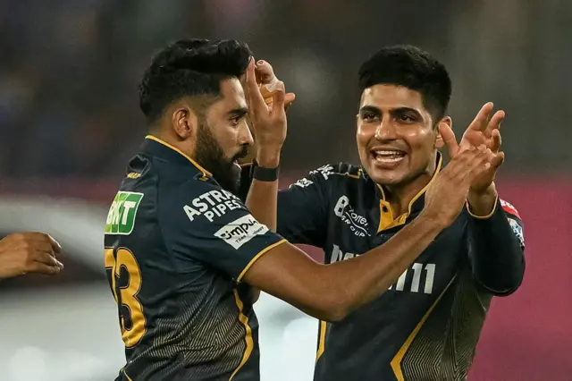 Gujarat Titans' Mohammed Siraj (L) celebrates with captain Shubman Gill after taking the wicket of Mumbai Indians' Rohit Sharma during the Indian Premier League (IPL) Twenty20 cricket match between Gujarat Titans and Mumbai Indians at the Narendra Modi Stadium in Ahmedabad on March 29, 2025.