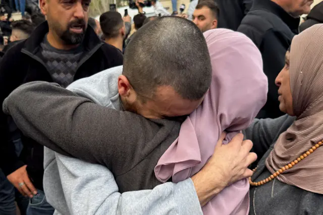 Zagrljaj muškarca sa ženom pokrivenom roze maramom