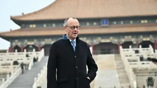 فردریش مرتس که در پسزمینه او به نظر یک عمارت کهن چینی است