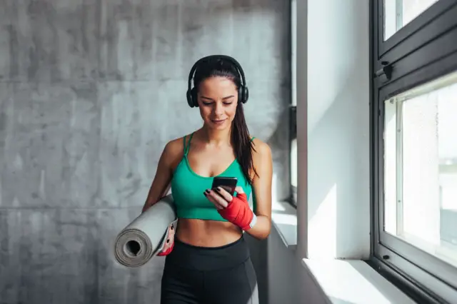 जिममध्ये मोबाईल वापरणारी महिला 