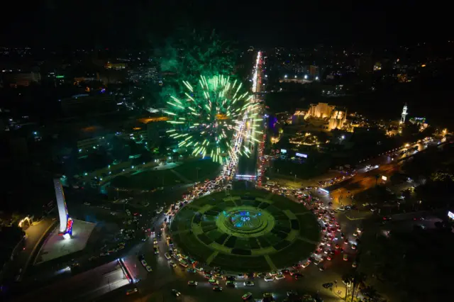 احتفالات السوريين في دمشق عقب خطاب الرئيس السوري المؤقت أحمد الشرع بعد رفع العقوبات الأمريكية عن سوريا، 14 مايو/ أيار 2025، ويظهر أن العديد من المباني في العاصمة السورية غير مضاءة.