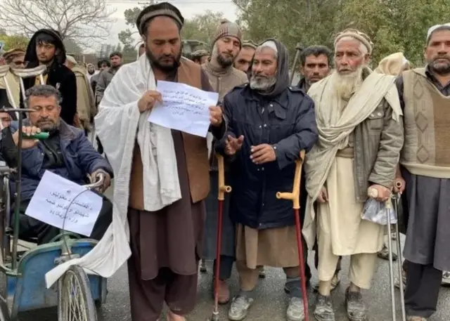 Des infirmes afghans tenant des pancartes