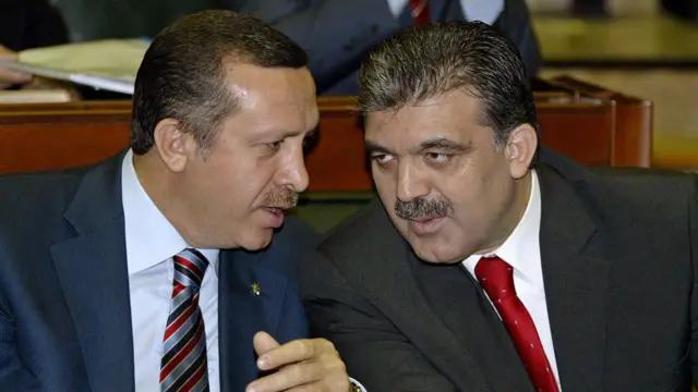 Recep Tayyip Erdoğan ve Abdullah Gül eğilmiş, birbirleriyle konuşuyorlar.