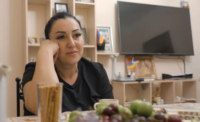 Светлана Бедросова, беженка из карабахского города Шуша сидит в съемной квартире на фоне картины — единственной вещи, которую они успели взять с собой, убегая из Карабаха. На картине изображен главный собор Шуши — церковь Казанчецоц.
