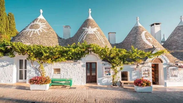 Fotografia das icônicas casas Trulli na cidade de Alberobello, Patrimônio Mundial da Unesco, na região da Puglia, Itália.