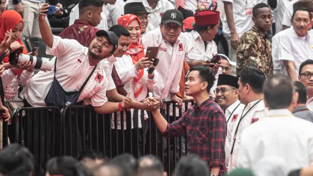 Wali Kota Surakarta Gibran Rakabuming Raka (kanan) menyapa relawan Projo dalam Rakernas VI Projo di Indonesia Arena GBK, Jakarta, Sabtu (14/10/2023).