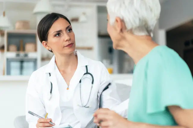 Una doctora atendiendo a una mujer mayor 