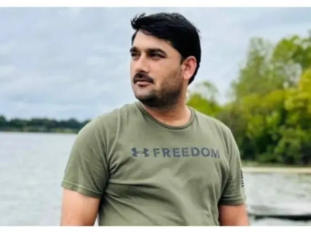 د محمد نذیر پکتیاوال انځور چې خپل ښيي خواته یې کتلي او شا ته یې د اوبو سیند او شینې ونې ښکاري.