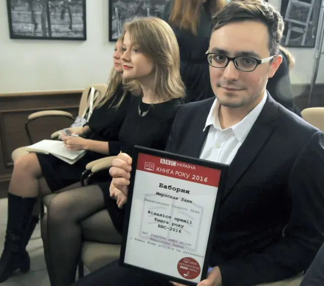 Мирослав Лаюк тримає в руках диплом фіналіста "Книги року ВВС" 2016 року.
