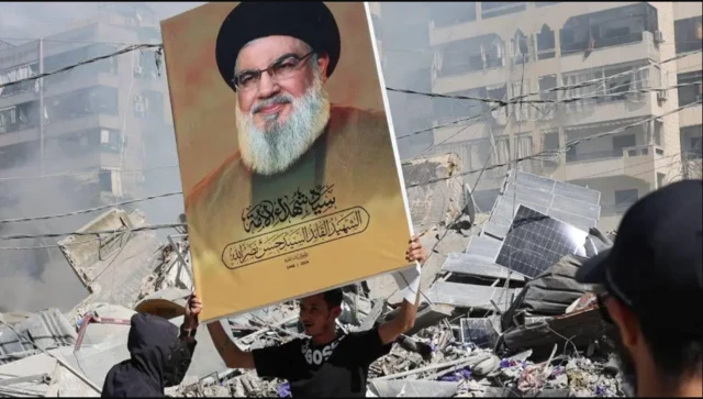 حسن نصرالله، که تصویر او پس از مرگش روی پوستری در دست جوانی در بیروت دیده می‌شود، نقشی کلیدی در «محور مقاومت» به رهبری ایران داشت