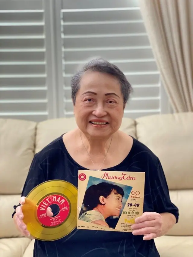 Phuong Tam holding album cover