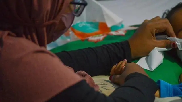 Seorang ibu sedang menunggui anaknya yang mengidap gangguan ginjal akut di Sumatera Barat.