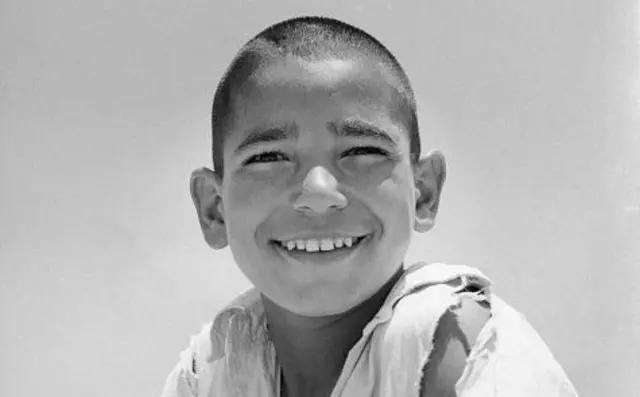 یو افغان ماشوم چې غالبا په ۱۹۶۵ کال د کامرې مخې ته مسکی ښکاري