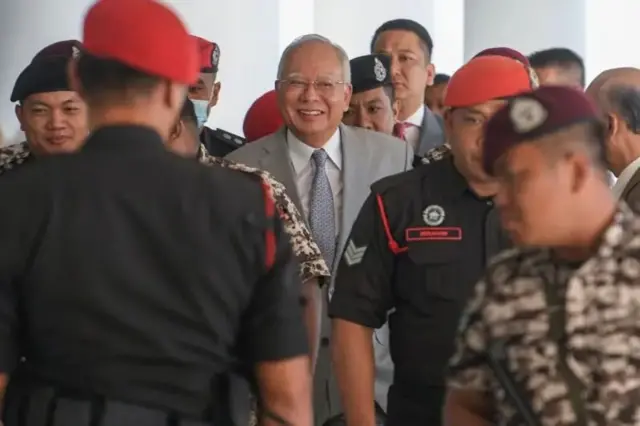 نجیب رزاق لبخندزنان در میان چند نظامی