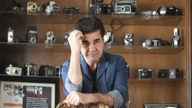 جعفر پناهی کارگردان ایرانی در کنار مجموعهای از دوربینهای عکاسی