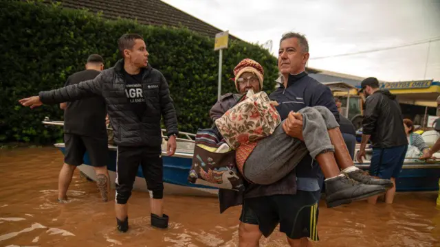 Idosa sendo carregada no colomelhores casas de apostas para cantosmeio à enchente