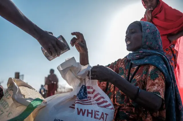 An internally displaced woman receives a can during a food distribution at Berley Camp, 20 kilometres from the city of Gode, Ethiopia, on January 10, 2023.