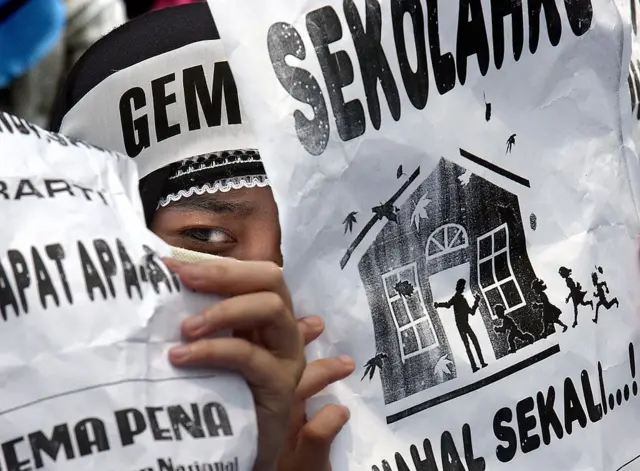 Aksi demonstrasi oleh peserta didik yang memajang poster menuntut akses pendidikan yang lebih murah.