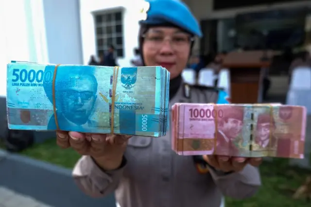 Petugas menunjukan uang rupiah palsu sebelum dimusnahkan di Kantor Polresta Solo, Jawa Tengah, Selasa (19/5/2026).
