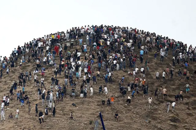 En la foto se ve a cientos de personas en un pequeño espacio tras cruzar la frontera.