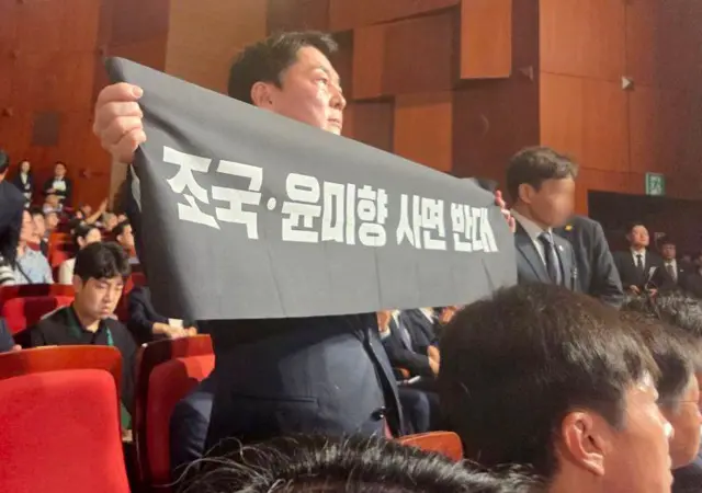 안철수 국민의힘 당대표 후보가 15일 오전 서울 종로구 세종문화회관에서 열린 제80주년 광복절 경축식에 참석해 경축사 중인 이재명 대통령을 향해 조국 전 조국혁신당 대표와 윤미향 전 의원의 사면 반대 플래카드를 들어보이며 항의하고 있다