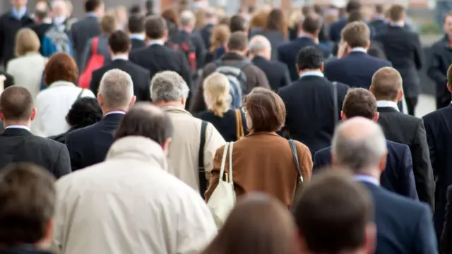 Pracownicy biurowi idący przez Most Londyński w drodze do domu w godzinach szczytu.