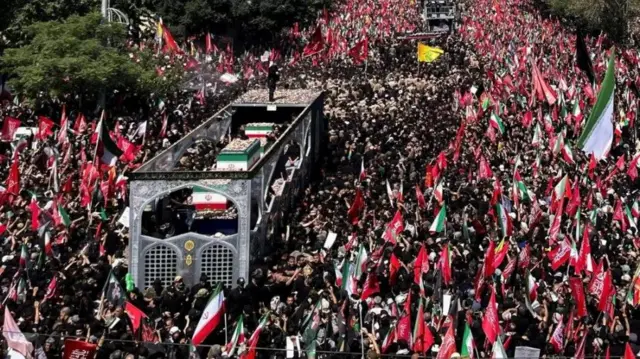 Imodoka ireruye isandugu y'ikiziga ca Ayatollah Ali Khamenei yari ikikujwe n'abari mu rugendo rwo kumusezera 