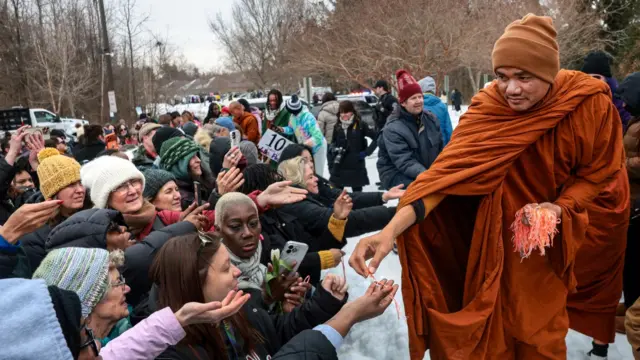 Монахи раздают освященные браслеты из ниток у здания Универсалистской общины Фредериксбурга во время «Похода мира» — группы из двух десятков буддийских монахов, которые идут пешком из Техаса в Вашингтон, округ Колумбия, в Фредериксбурге, штат Вирджиния, США, 6 февраля 2026 года.
