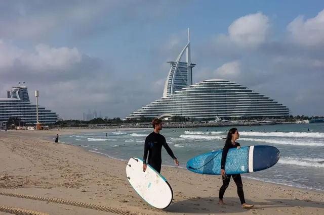 Unos surfistas en una playa de Dubái.