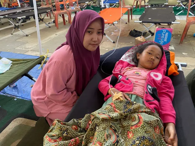 Seorang ibu sedang menemani anaknya yang sakit.