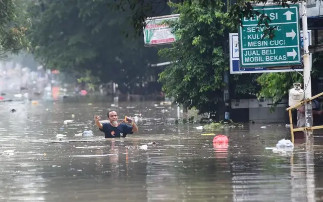 Anggota Brimob Mabes Polri mengevakuasi korban banjir di perumahan Vila Nusa Indah 3, Bogor, Selasa (04/03).