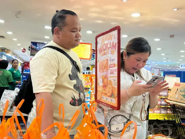 Sianna, penyandang tuli-buta, bersama suaminya sedang memeriksa barang yang hendak dibelinya