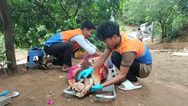 ဒဏ်ရာရနေတဲ့ ကိုယ်ဝန်ဆောင်ကို ပရဟိတအဖွဲ့တွေက ဆေးရုံပို့ပေးကြပါတယ်။