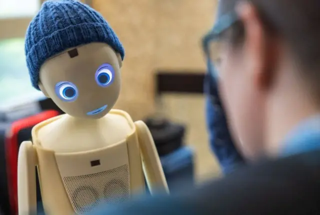 زائر يتحدث مع روبوت Navel، من شركة Navel Robotics، خلال القمة العالمية للذكاء الاصطناعي من أجل الخير حول الذكاء الاصطناعي، التي نظمها الاتحاد الدولي للاتصالات (ITU)، في جنيف، سويسرا، 30 مايو/أيار 2024.