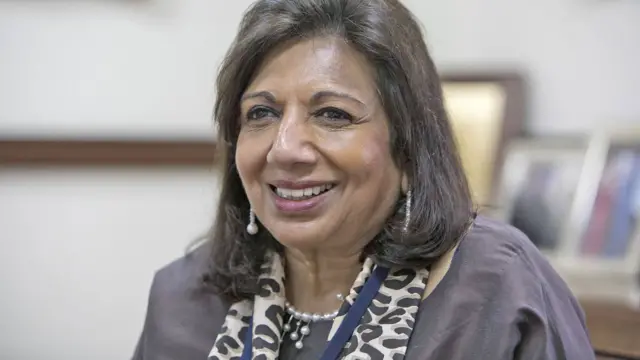 Usando um colarcasas de apostas betanopérolas, Kiran Mazumdar-Shaw, sorri durante uma entrevista