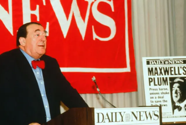Maxwell en conferencia de prensa con copia del Daily News anunciando el acuerdo.