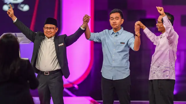 Cawapres nomor urut 1 Muhaimin Iskandar (kiri), cawapres nomor urut 2 Gibran Rakabuming Raka (tengah), dan cawapres nomor urut 3 Mahfud MD (kanan) bergandengan tangan usai mengikuti debat cawarpres pertama.