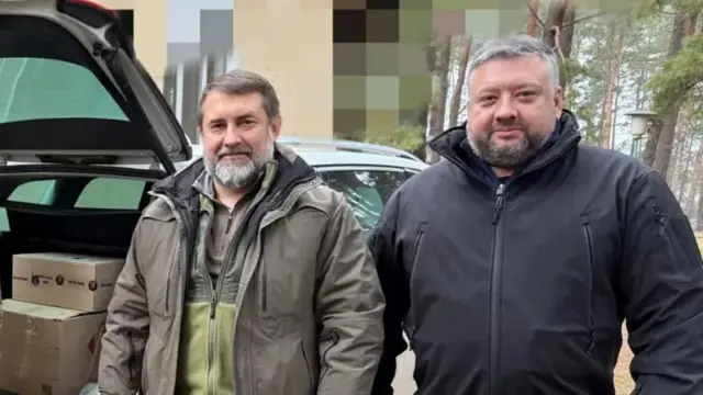 Сергій Гайдай (ліворуч) і Олексій Кузнєцов (праворуч) під час передачі допомоги військовим ЗСУ