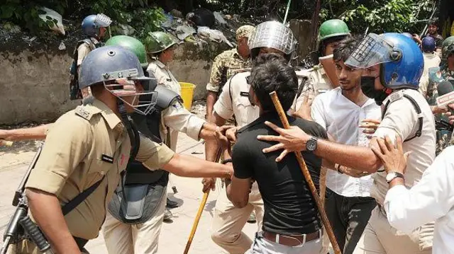 Police personnel detains youths and students during a 'Bihar Bandh' protest demanding the resignation of Union Education Minister Dharmendra Pradhan over alleged irregularities in the NEET examination, at Dak Bungalow crossing on July 25, 2026 in Patna, India. 