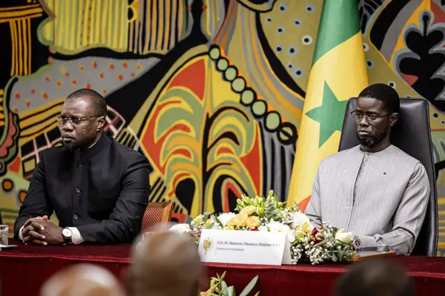 Le président sénégalais Bassirou Diomaye Faye et son premier ministre Ousmane Sonko assistent à une cérémonie au palais présidentiel de Dakar, le 16 octobre 2025, après avoir reçu le rapport officiel sur le massacre de Thiaroye. 