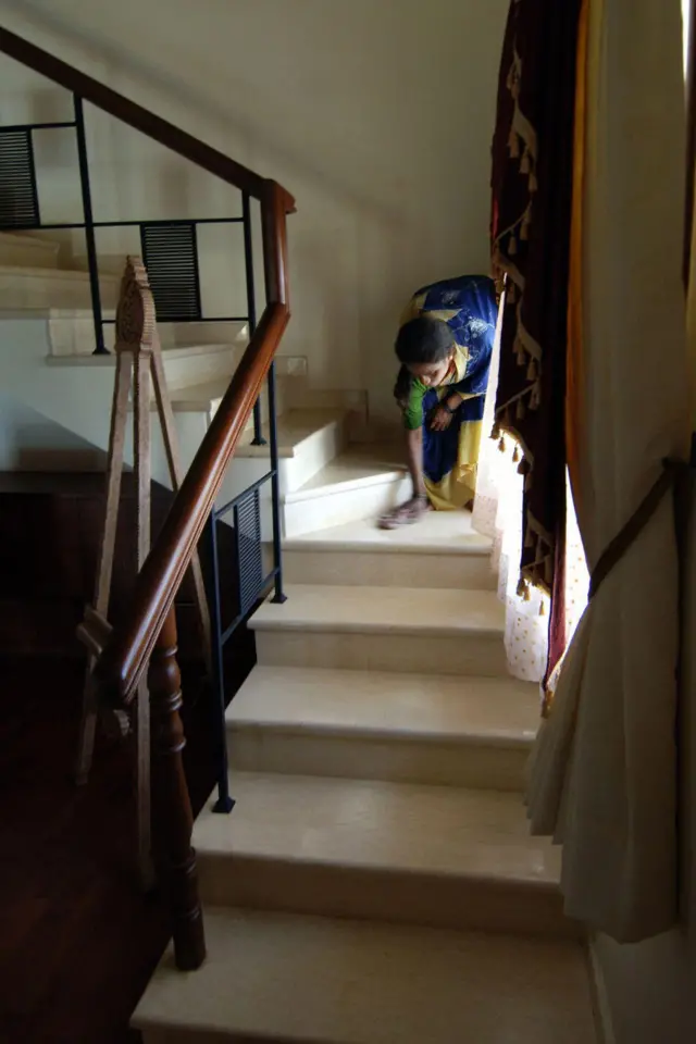  An Indian worker of the construction firm Alliance Infrastructure Projects Limited cleans a stairway in a show house at a new housing development in Bangalore