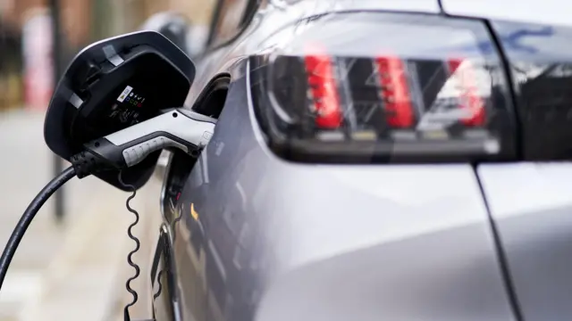 Вид сзади на серый электромобиль, подключенный к зарядной станции Source London EV.