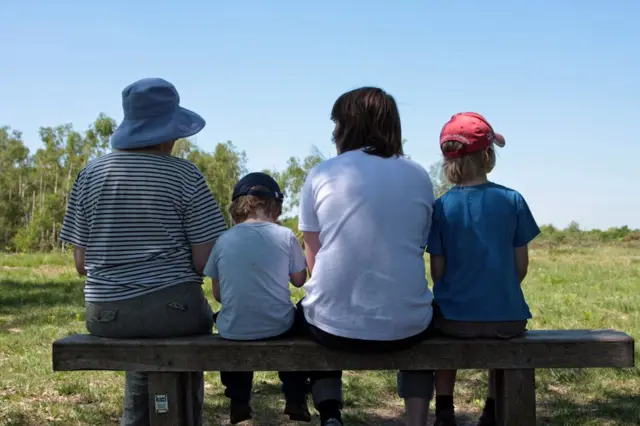 Žena i troje dece na klupi