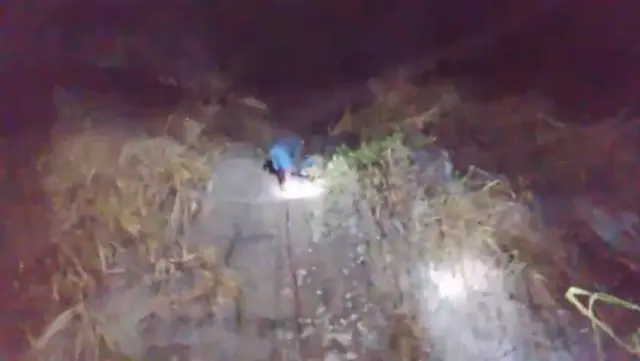 මුදා ගැනීමේ මෙහෙයුමට සම්බන්ධ පුද්ගලයෙක් තුවාලකරුවෙකු කඹයක් ආධාරයෙන් රැගෙන එන අයුරු